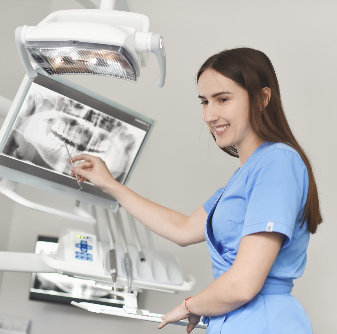 Odontologė Gabija komentuoja panoraminę dantų nuotrauką kompiuterio ekrane