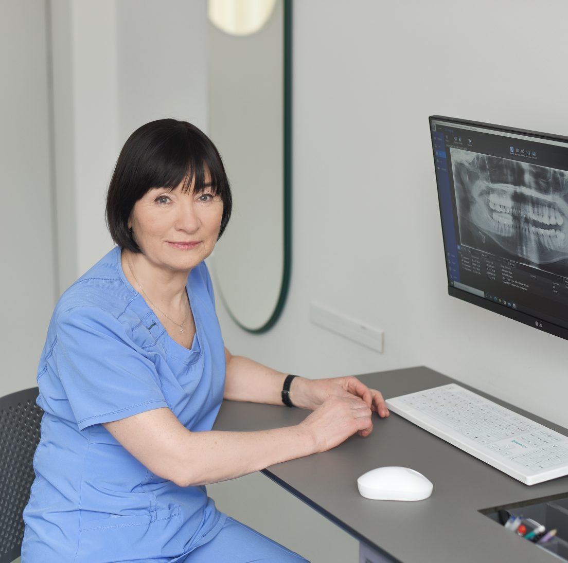 Odontologė Irena Zykuvienė ir panoraminė dantų rentgeno nuotrauka ekrane