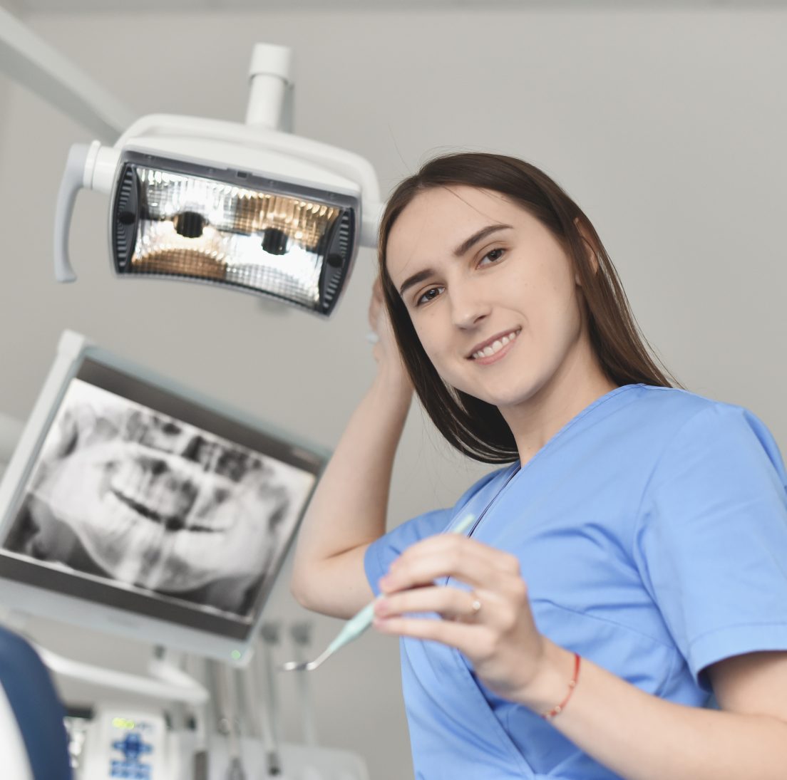 Panoraminė dantų nuotrauka ekrane ir odontologė Gabija