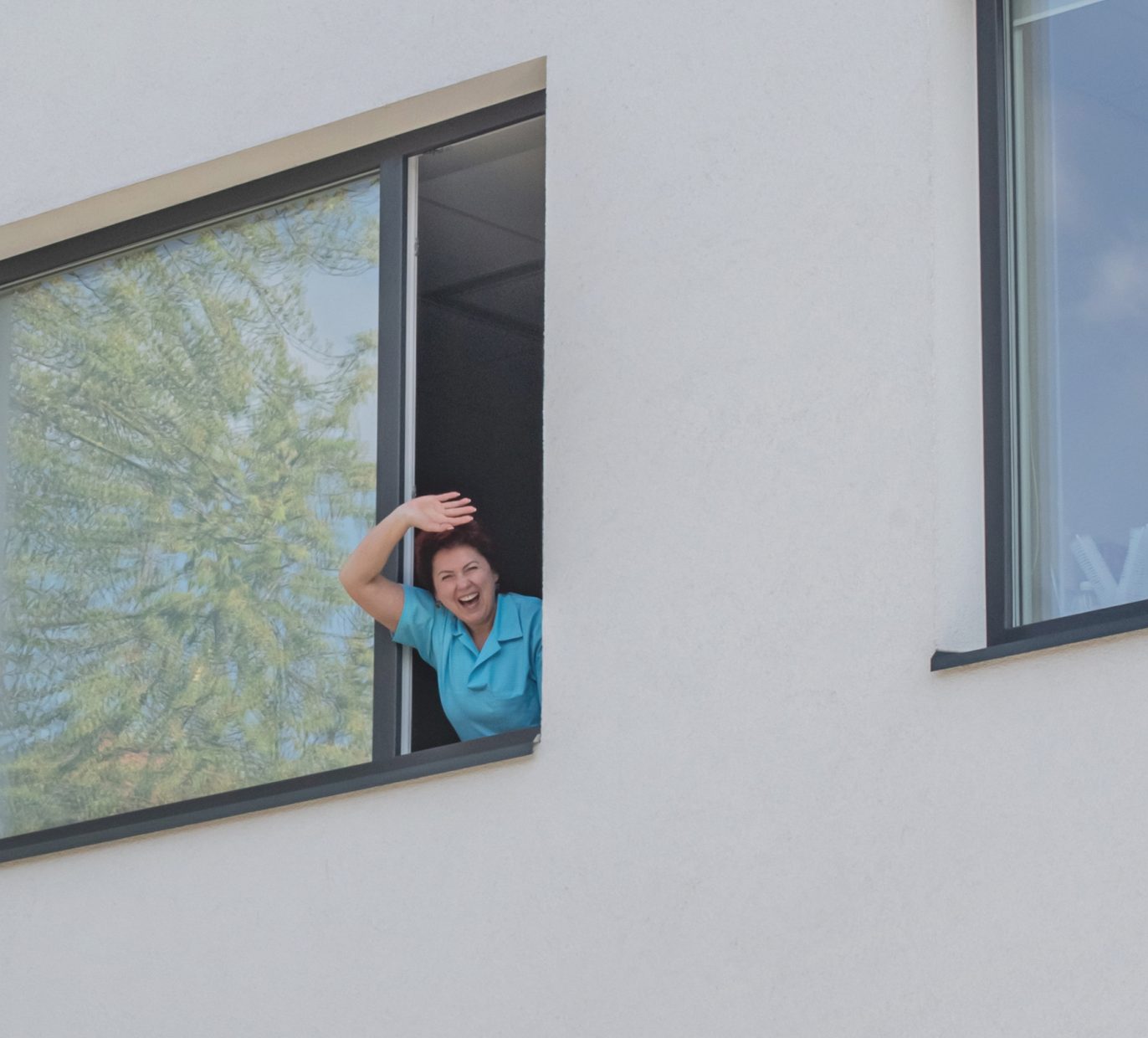 Burnos higienistė mojuoja pro odontologijos klinikos langą